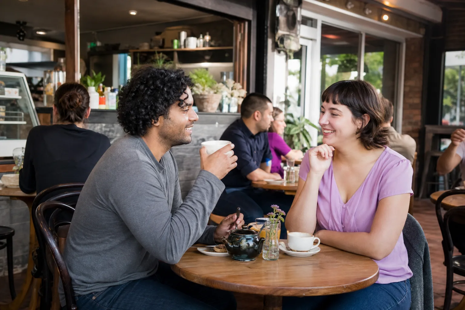Two adults talking over coffee at a relaxed Birmingham café